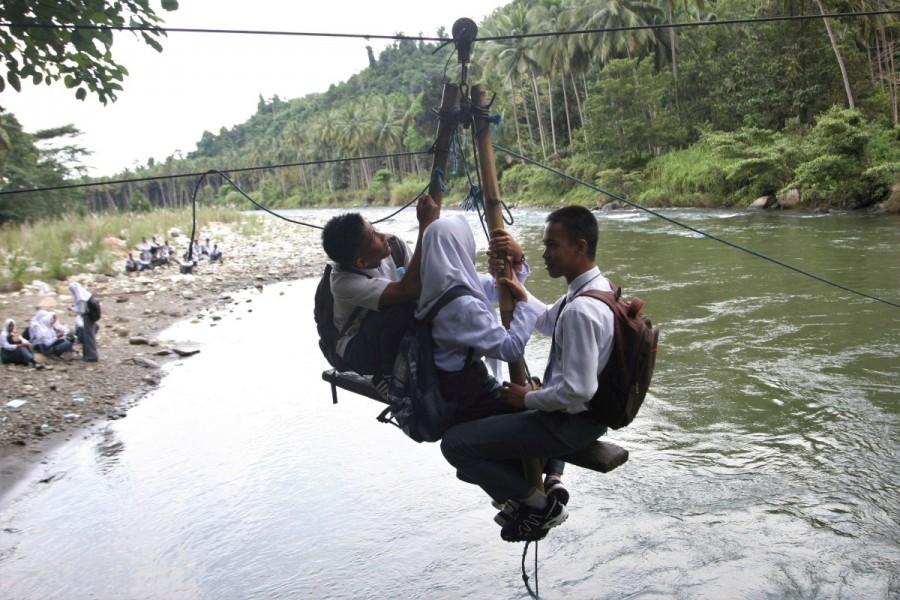 High school students cross the Ranteangin river on their way home in Maroko village, in Kolaka Utara, Indonesia. Long journey to school,journey to school