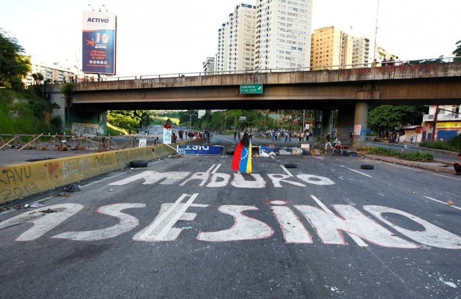 Demonstrators walk on an empty highway with the words "Maduro Assassin" painted on the surface after clashes broke out while the Constituent Assembly election was being carried out in Caracas, Venezuela, July 30, 2017. Venezuela election,Venezuela,protests over Venezuela election,Anti-government demonstrators,President Nicolas Maduro,Nicolas Maduro,Socialist Party