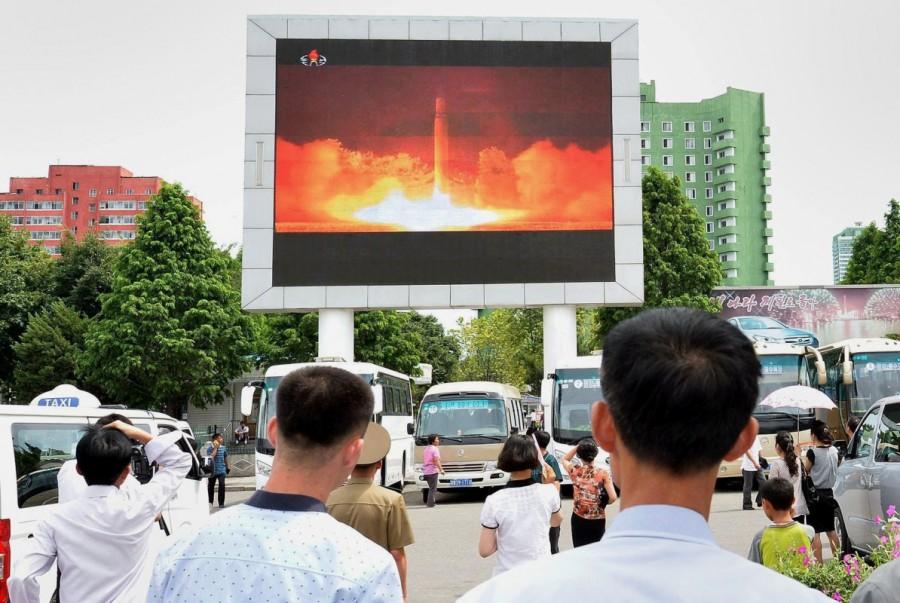 People watch news report showing North Korea's Hwasong-14 missile launch on electronic screen at Pyongyang station, North Korea. North Korea,North Korea missile program,evolution of North Korea missile program