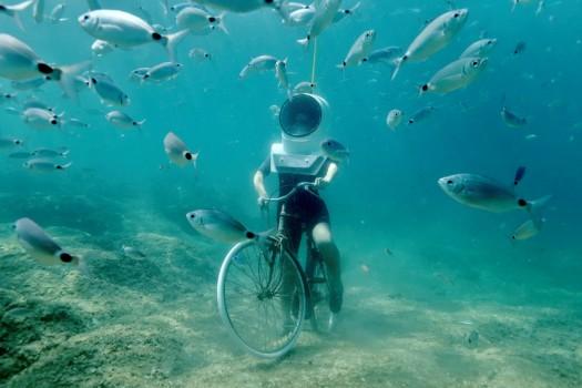 A woman dives and pretends to ride a bike in Underwater Park in Pula, Croatia, August 1, 2017.