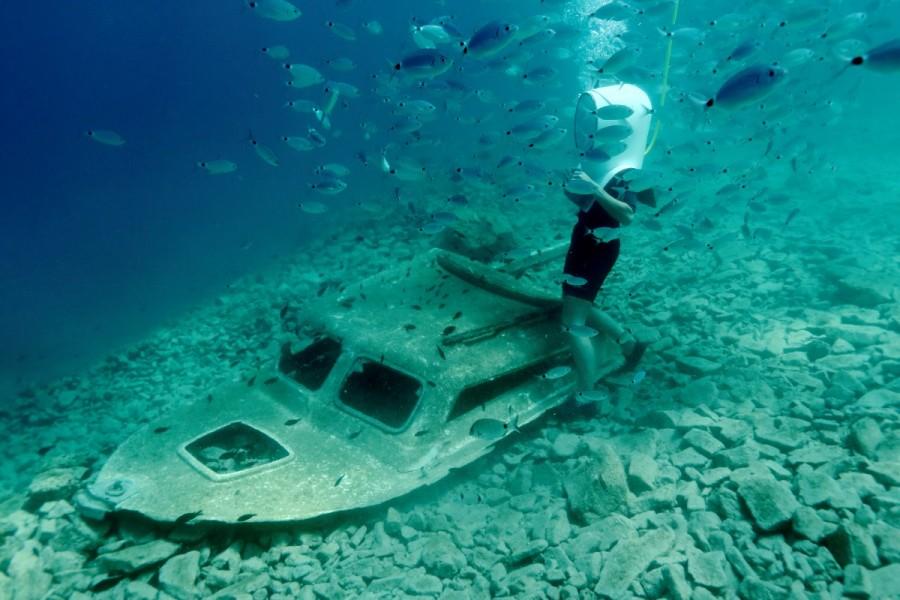 A woman dives next to a boat wreck. Croatia,Playing underwater,Playing underwater in Croatia