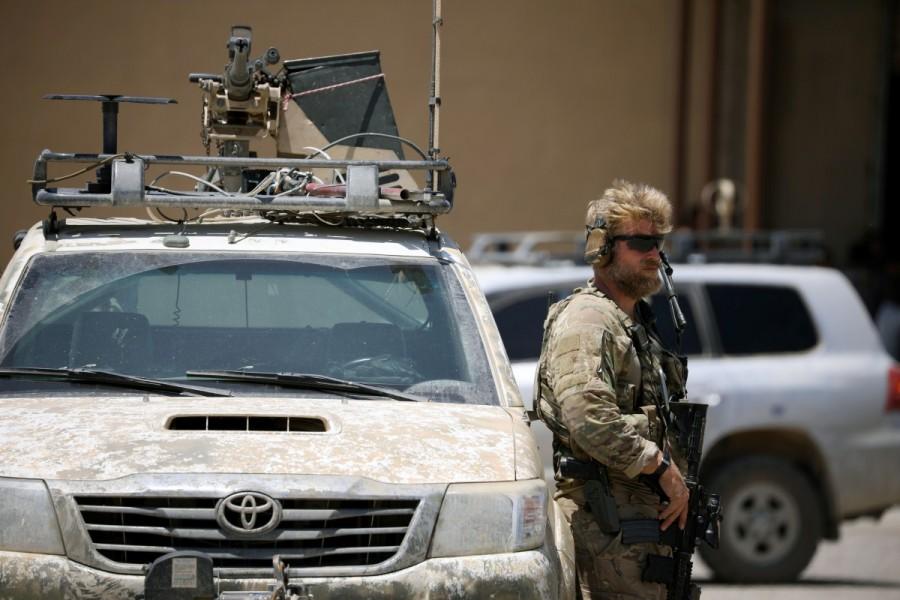A U.S army soldier stands guard next to an armored vehicle as Brett McGurk, U.S. envoy to the coalition against Islamic State, visits the town of Tabqa. June 2017. U.S. forces in Syria,U.S. forces,Syria,U.S. military forces