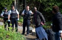 A family claiming to be from Haiti is confronted by Royal Canadian Mounted Police (RCMP) officers as they cross the US-Canada border. More than 4,300 asylum seekers crossed the U.S. border into Canada in the first six months of this year. Many told Reuters they feared Trump's immigration crackdown.