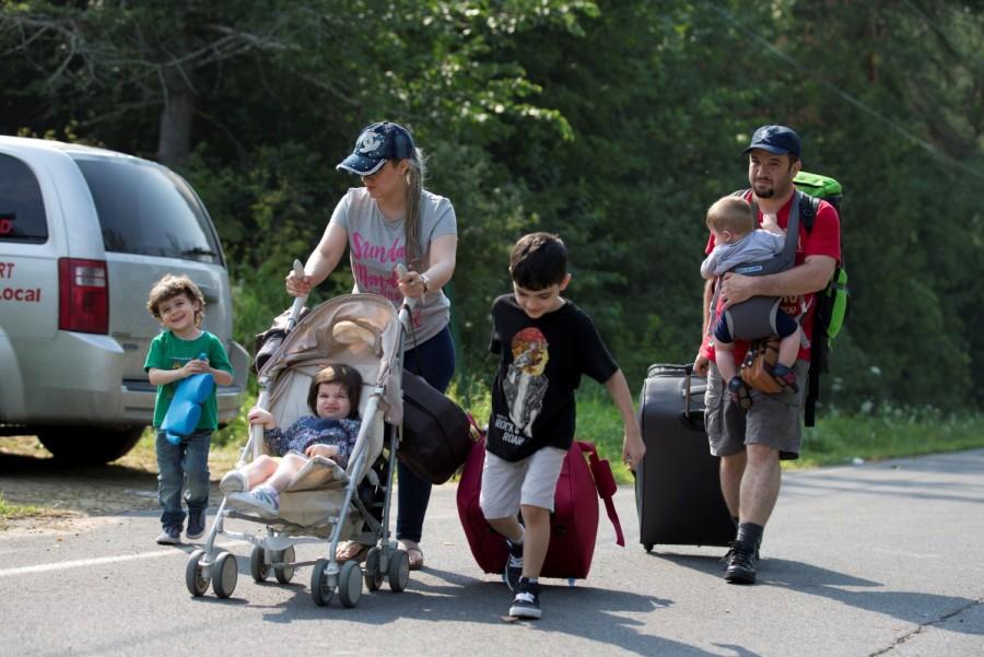Raed Alakhras from Syria arrives on Roxham Road by taxi with his family to cross the US-Canada border into Canada from Champlain, New York, August 3, 2017. Canada from the U.S.,Canada-U.S. border,U.S. border,Quebec