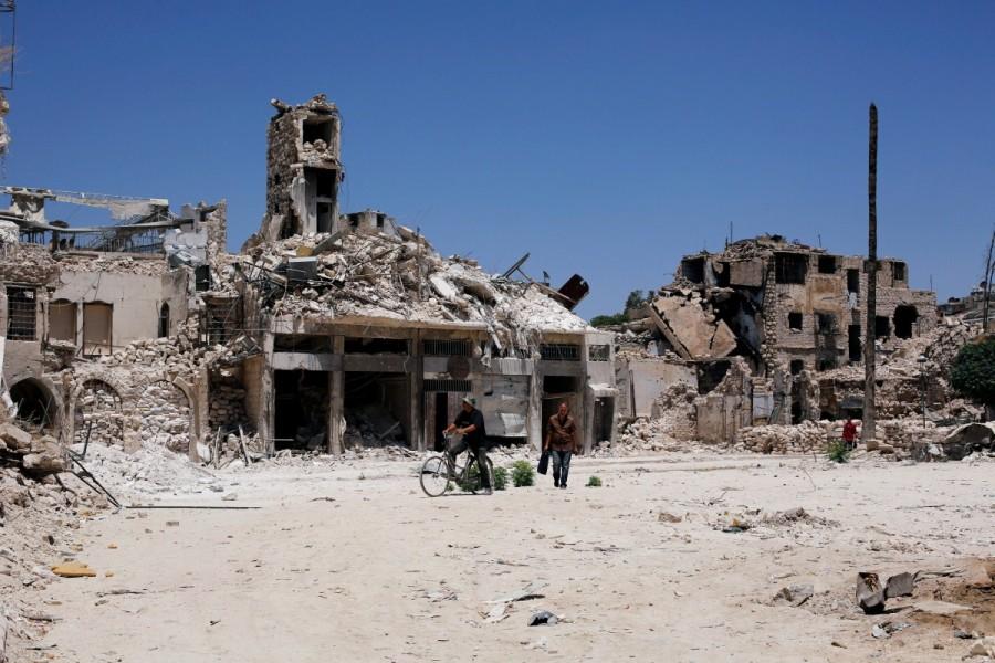 A man walks past damaged houses in the old city of Aleppo, Syria July 13, 2017. Whole districts of less celebrated alleyways and traditional houses that gave the Old City its character are also now rubble. Aleppo's Old City,Syria’s civil war,United Nations cultural body,UNESCO,Aleppo