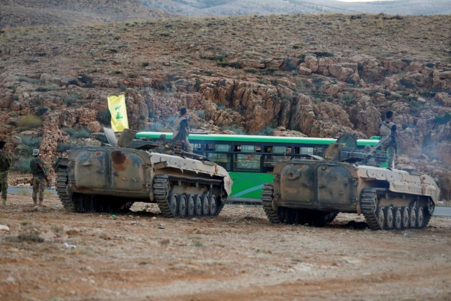 Hezbollah fighters are seen escorting buses in Jroud Arsal, Lebanon. Syrians evacuate Lebanon border,Lebanon border camps,Syrian militants,Syrian militants and refugees,Syrian refugees,Nusra Front militants
