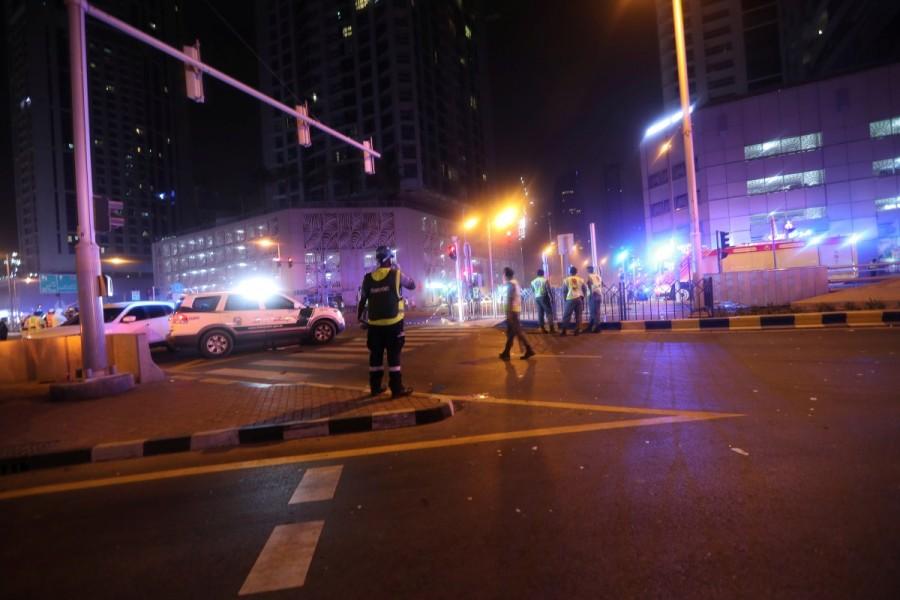 Dubai Emergency Response teams and Dubai police are seen on the street near Dubai's Torch tower residential building in the Marina district. Blaze sweeps,Dubai skyscraper,Blaze sweeps through Dubai skyscraper,Dubai,United Arab Emirates