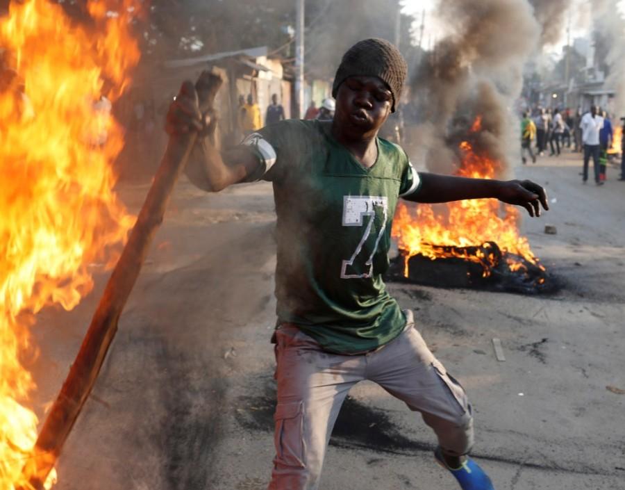 A supporter of opposition leader Raila Odinga sets up flaming tyre barricade in Kibera slum in Nairobi, Kenya, August 9, 2017. Raila Odinga,Kenya fake results,Kenya election,Kenya election fake results,Kenya's opposition leader Raila Odinga