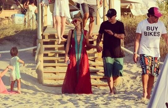 Socialite Paris Hilton looked happy during her holiday in Formentera with her boyfriend Chris Zylka as they enjoyed a boating session together. Hilton was spotted in a lacy red dress as she held hands with the actor as they crossed the beach and took a ride in a small boat on Friday, reports dailymail.co.uk.