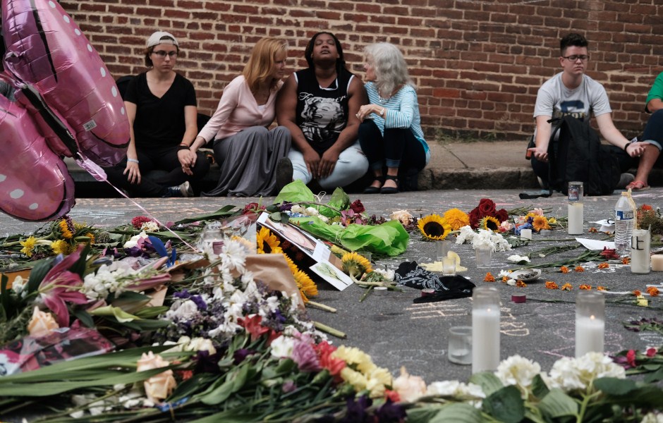 Women sit by an impromptu memorial of flowers commemorating the victims at the scene of the car attack on a group of counter-protesters during the "Unite the Right" rally as people continue to react to the weekend violence in Charlottesville, Virginia. Charlottesville violence,Aftermath of deadly Charlottesville violence,Charlottesville,Virginia