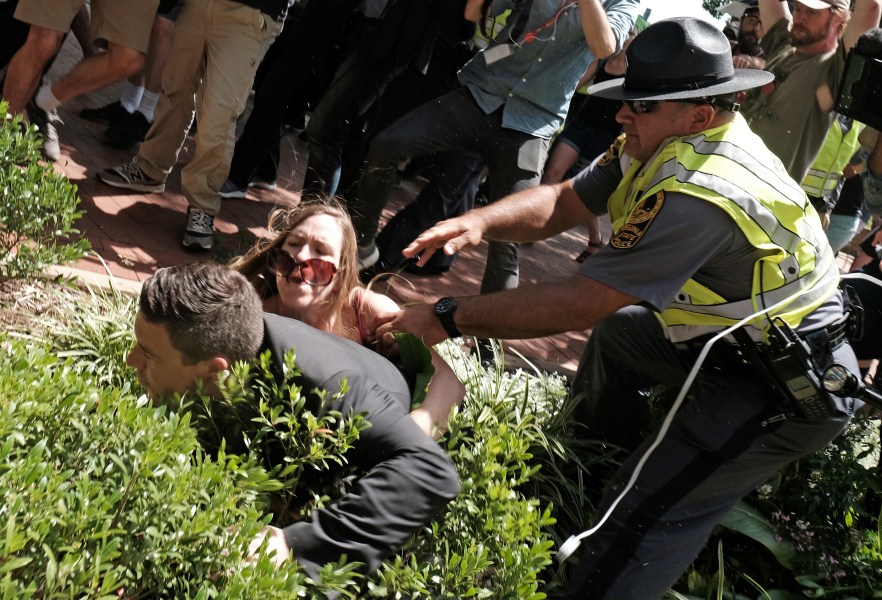 Unite The Right rally organizer Jason Kessler is helped by police after being tackled by a woman after he attempted to speak at a press conference in front of Charlottesville City Hall in Charlottesville, Virginia. Charlottesville violence,Aftermath of deadly Charlottesville violence,Charlottesville,Virginia