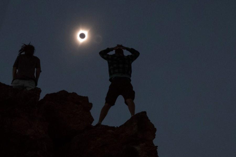 Enthusiasts Tanner Person (R) and Josh Blink, both from Vacaville, California, watch a total solar eclipse while standing atop Carroll Rim Trail at Painted Hills, a unit of the John Day Fossil Beds National Monument, near Mitchell, Oregon, U.S. August 21, 2017. Solar eclipses,breathtaking photos of solar eclipses,solar eclipses pics,solar eclipses images,solar eclipses stills,solar eclipses around America
