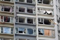 A man looks out from inside an apartment where some windows have been broken by typhoon Hato in Macau.