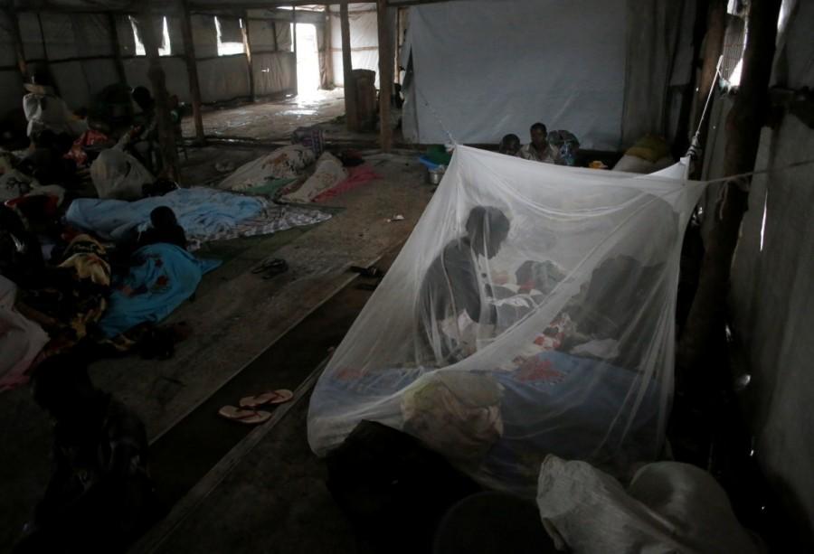A South Sudanese refugee woman takes care of her baby under a mosquito net in a transit tent at the Imvepi refugee settlement camp in Arua District, northern Uganda. South Sudanese refugees,South Sudanese refugees in Uganda,Uganda,Sudanese refugees