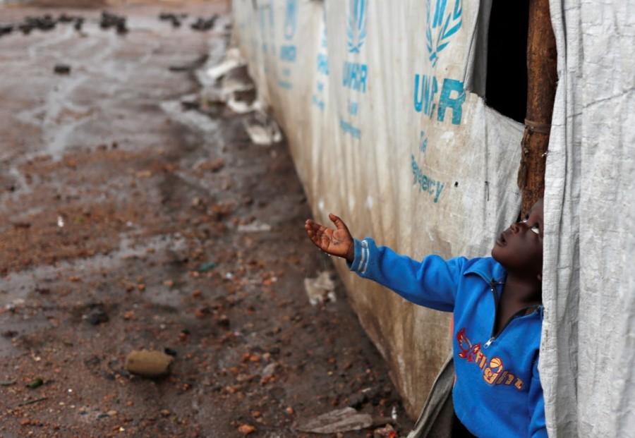 A South Sudanese refugee boy catches raindrops in Imvepi refugee settlement camp in Arua District, northern Uganda. South Sudanese refugees,South Sudanese refugees in Uganda,Uganda,Sudanese refugees