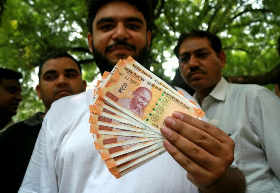A man shows the new Rs 200 currency note outside Reserve Bank of India in New Delhi on Aug 25, 2017. Rs 50,Rs 200,RBI issues new Rs 50 note,RBI issues new Rs 200 note,Rs 200 note,Rs 200 note pics,Rs 200 note images,Rs 200 note stills,Rs 200 note pictures,Rs 200 note photos,Reserve Bank of India