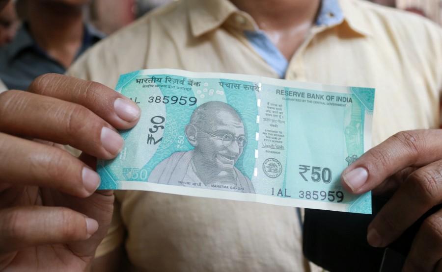 A man shows the new Rs 50 currency note outside Reserve Bank of India in New Delhi on Aug 25, 2017. Rs 50,Rs 200,RBI issues new Rs 50 note,RBI issues new Rs 200 note,Rs 200 note,Rs 200 note pics,Rs 200 note images,Rs 200 note stills,Rs 200 note pictures,Rs 200 note photos,Reserve Bank of India