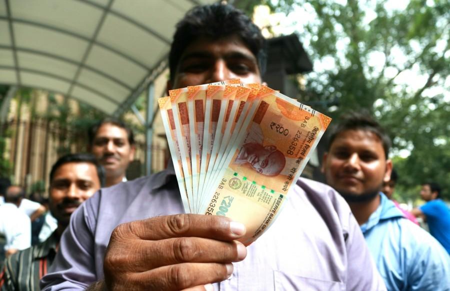 A man shows the new Rs 200 currency note outside Reserve Bank of India. Rs 50,Rs 200,RBI issues new Rs 50 note,RBI issues new Rs 200 note,Rs 200 note,Rs 200 note pics,Rs 200 note images,Rs 200 note stills,Rs 200 note pictures,Rs 200 note photos,Reserve Bank of India
