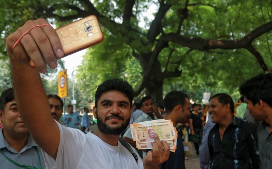 A man shows the new Rs 200 currency note outside Reserve Bank of India in New Delhi on Aug 25, 2017. Rs 50,Rs 200,RBI issues new Rs 50 note,RBI issues new Rs 200 note,Rs 200 note,Rs 200 note pics,Rs 200 note images,Rs 200 note stills,Rs 200 note pictures,Rs 200 note photos,Reserve Bank of India