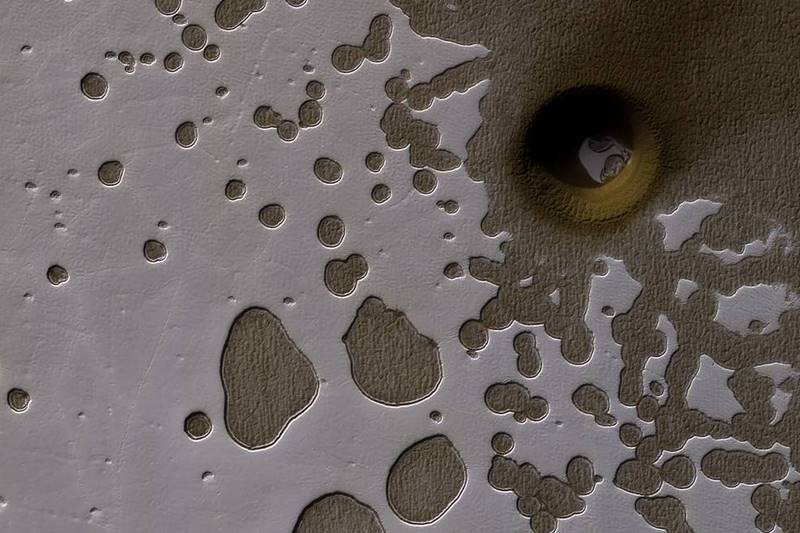 When the sun starts shining on it in the spring, the ice on the smooth surface of the dune cracks and escaping gas carries dark sand out from the dune below, often creating beautiful patterns. NASA,NASA Mars,snowy dunes,stunning picture of dunes,Mars with snow,Mars with snow and ice on ridges