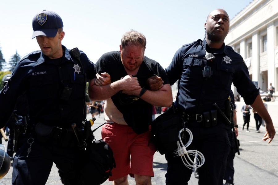 Police officers help an injured man after he was attacked by masked demonstrators. No Marxism,No Marxism rally,Rally Against Hate,No Marxism in America