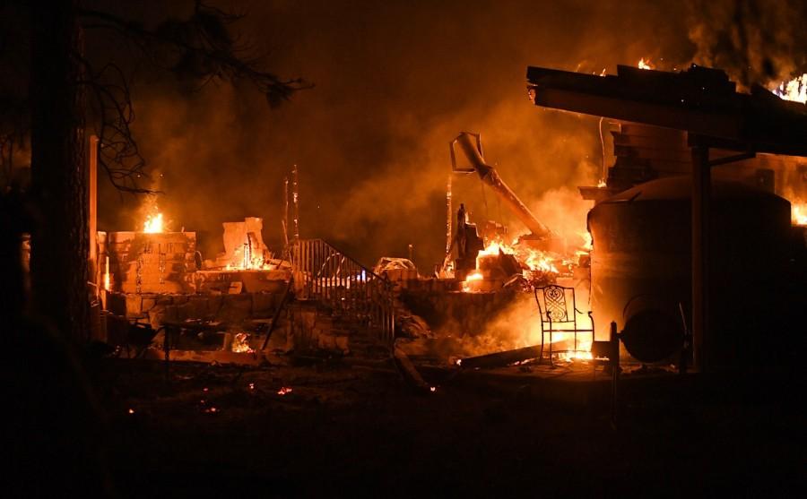 Flames consume a garage as the Ponderosa Fire burns east of Oroville. Fast-moving wildfire,wildfire,wildfire in Northern California,Northern California,California,California wildfire