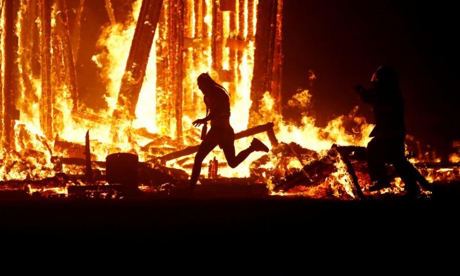 A Burning Man participant evades a chasing firefighter and runs into the flames of the "Man Burn" after evading the attempted tackles of multiple rangers and law enforcement personnel at the annual Burning Man arts and music festival in the Black Rock Desert of Nevada, U.S. September 2, 2017. Burning Man festival,Burning Man festival 2017,Burning Man,Man runs into flames,firefighters
