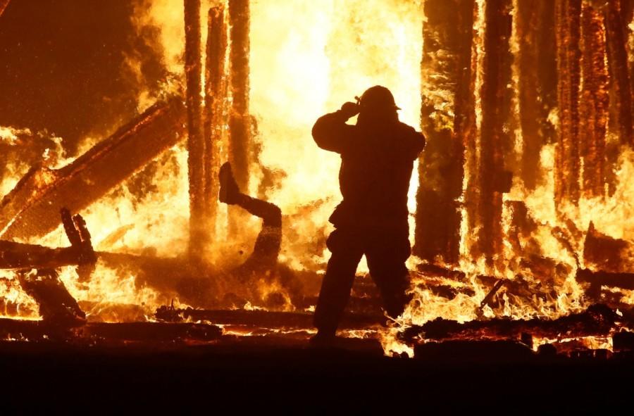 A Burning Man participant (L) evades a chasing firefighter and falls into the flames of the "Man Burn" after evading the attempted tackles of multiple rangers and law enforcement personnel at the annual Burning Man arts and music festival in the Black Rock Desert of Nevada. Burning Man festival,Burning Man festival 2017,Burning Man,Man runs into flames,firefighters