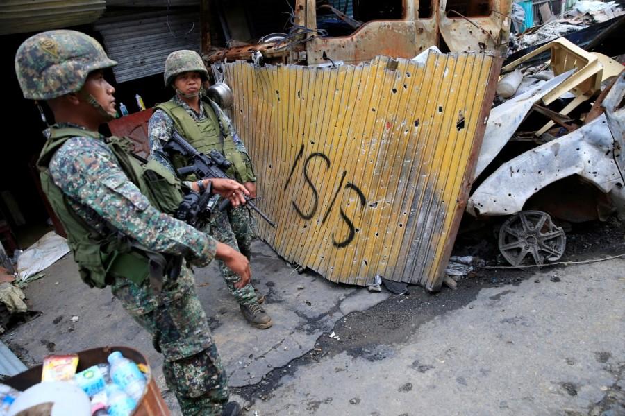 Government soldiers stand on guard in front of damaged buildings as troops continue their assault on its 105th day of clearing operations against pro-IS militants who have seized control of large parts of Marawi City, Philippines September 4, 2017. Marawi City,Philippine city,Islamic State,government forces fight