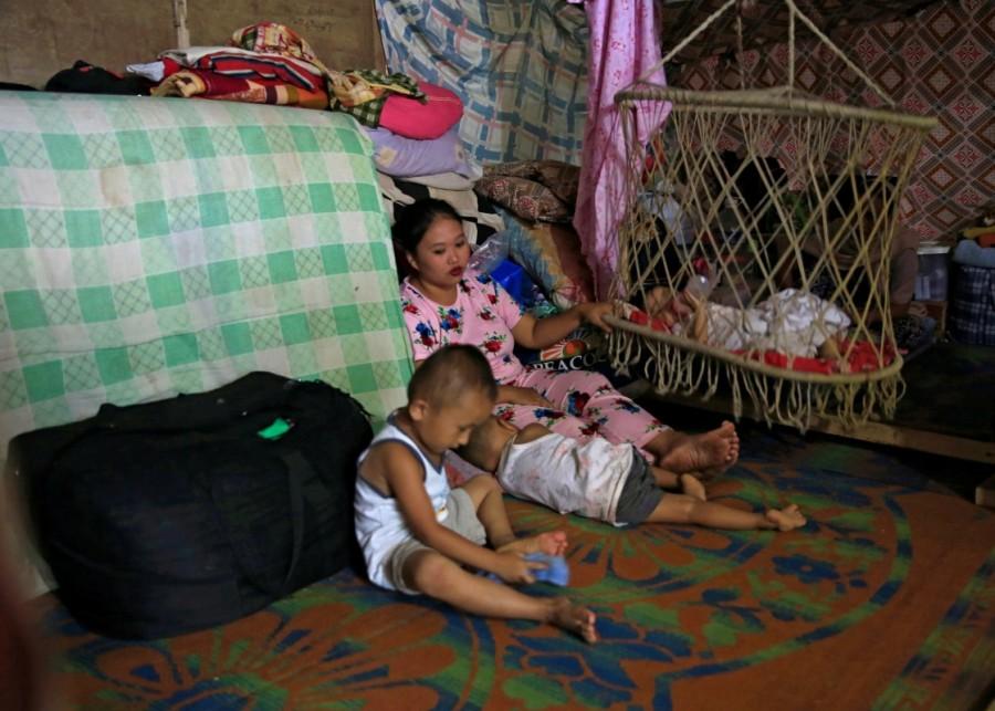 A mother with her children takes a break in an evacuation center, after families fled their homes from Marawi City to avoid the fighting between government troops and pro-IS militants group, in Saguiaran town, Lanao del Sur province, southern Philippines September 6, 2017. Marawi City,Philippine city,Islamic State,government forces fight