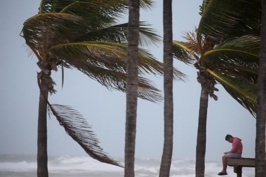 A man sits on a lifeguard tower as the wind blows in advance of Hurricane Irma in Hollywood, Florida.
