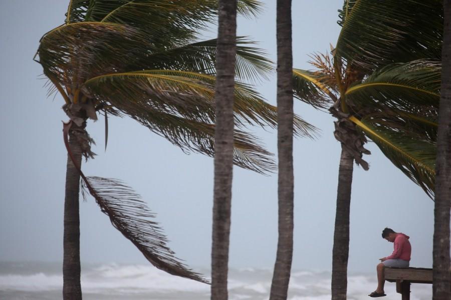 A man sits on a lifeguard tower as the wind blows in advance of Hurricane Irma in Hollywood, Florida. Hurricane Irma,Hurricane,Hurricane Irma in Florida,Hurricane in Florida,Florida,Florida Hurricane