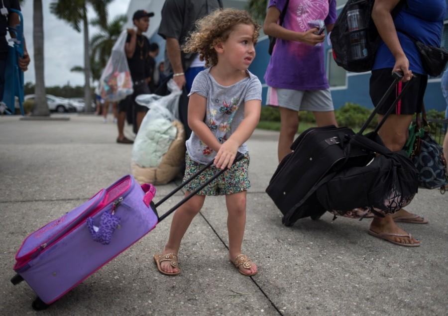 Chloe Rosenberger, a three-year old from Cape Coral, Florida, carries her belongings while following her brother and mother into a shelter in Estero. Hurricane Irma,Hurricane,Hurricane Irma in Florida,Hurricane in Florida,Florida,Florida Hurricane