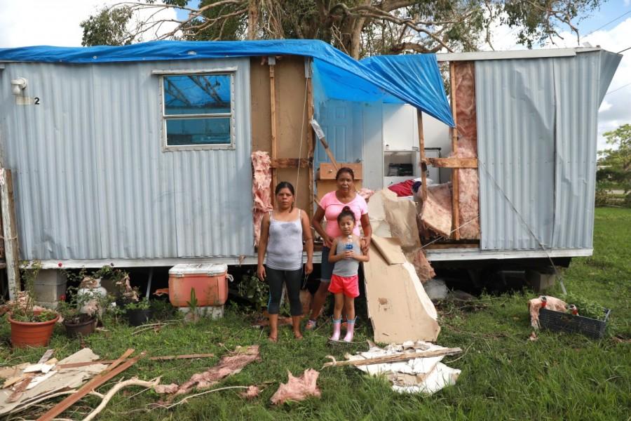 Sandra Guzman, left, with her daughter Maria Valentine Romero, right, and their friend Rosa Pulito, back, are pictured in front of Sandra's mobile home in Immokalee. Hurricane Irma,Florida Hurricane Irma,devastation in Florida