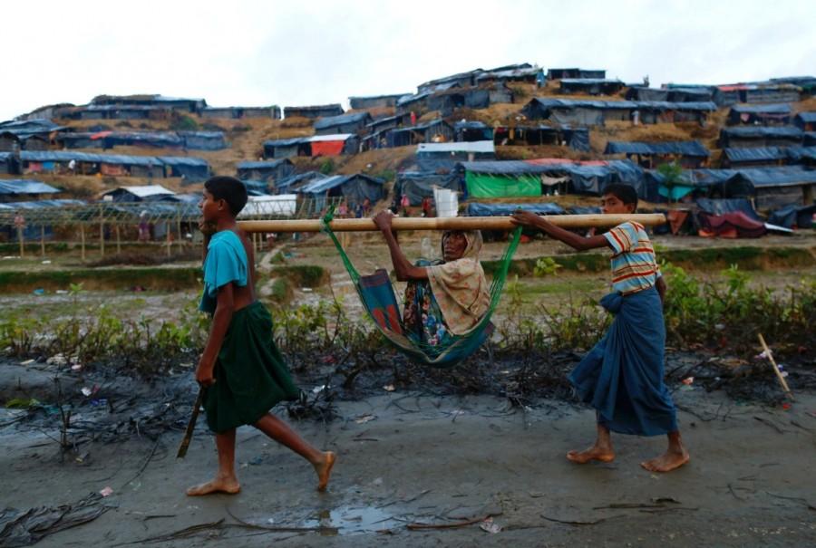 Rohingya refugee children carry an old woman in a sling near Balukhali makeshift refugee camp in Cox's Bazar, Bangladesh. Myanmar,Myanmar violence,Muslim Rohingya,Rohingya flee Myanmar violence