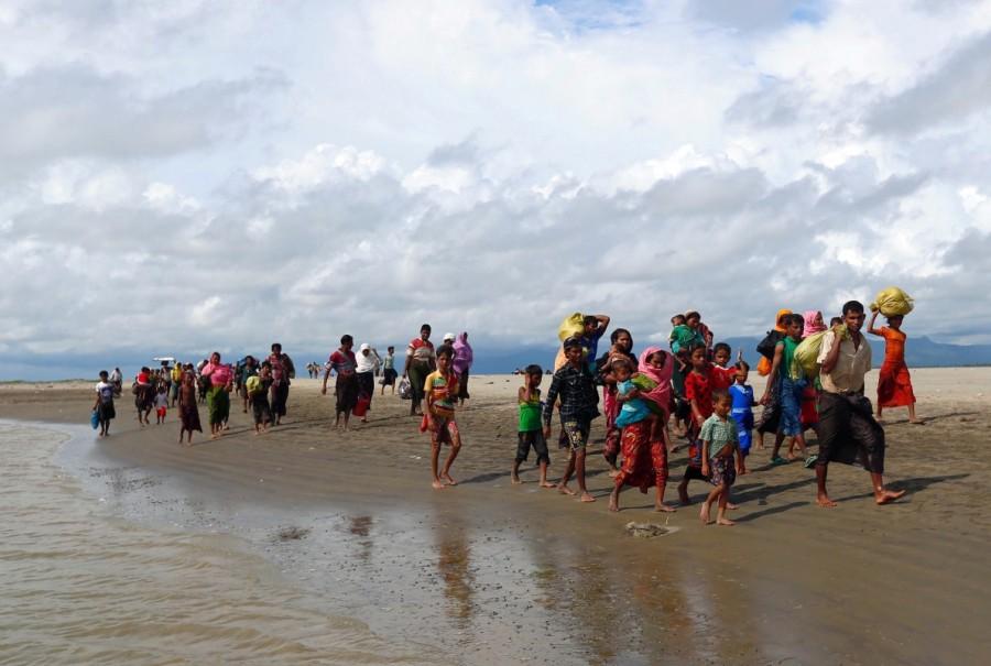 Rohingya refugees walk on the shore after crossing the Bangladesh-Myanmar border by boat through the Bay of Bengal in Shah Porir Dwip, Bangladesh. Myanmar,Myanmar violence,Muslim Rohingya,Rohingya flee Myanmar violence