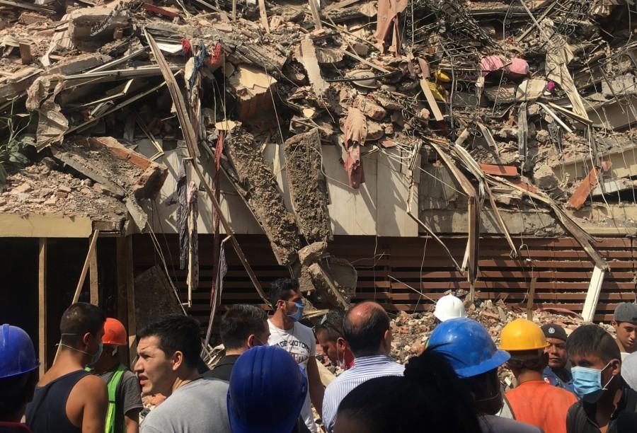 Image taken with a mobile phone shows people watching a collapsed building after an earthquake in Mexico City, capital of Mexico, on Sept. 19, 2017. More than 100 people were killed in a powerful 7.1-magnitude earthquake that hit central Mexico on Tuesday, and the number of deaths is expected to rise due to the scale of the quake. Earthquake,Mexico,Mexico earthquake,7.1-magnitude,7.1-magnitude earthquake,7.1-magnitude earthquake in Mexico