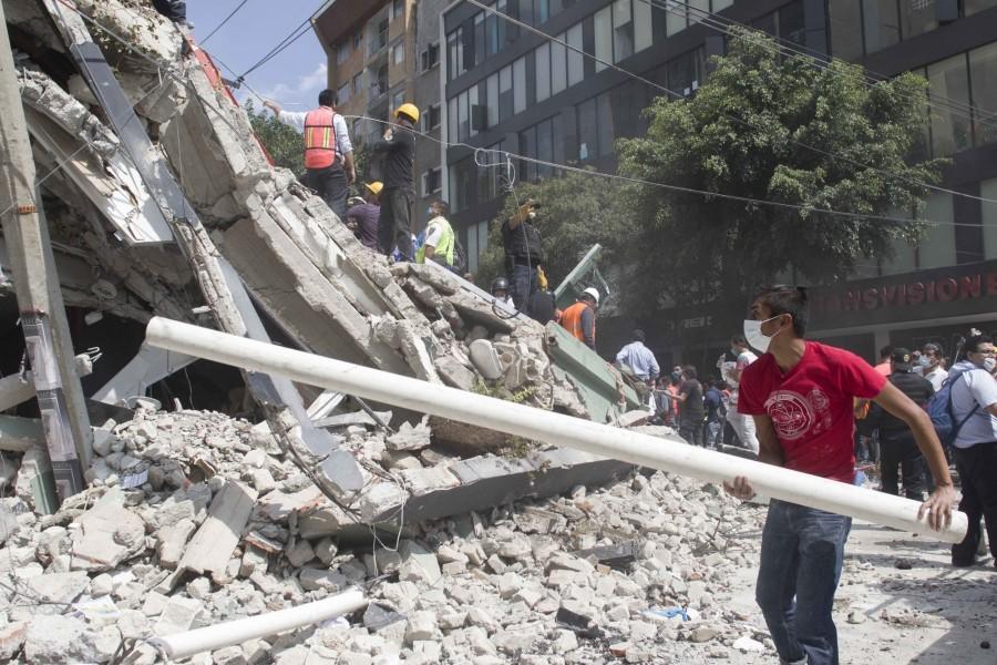 People work near a collapsed building after an earthquake in Mexico City, capital of Mexico, on Sept. 19, 2017. More than 100 people were killed in a powerful 7.1-magnitude earthquake that hit central Mexico on Tuesday, and the number of deaths is expected to rise due to the scale of the quake. Earthquake,Mexico,Mexico earthquake,7.1-magnitude,7.1-magnitude earthquake,7.1-magnitude earthquake in Mexico