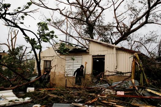 A man looks for valuables in the damaged house of a relative after the area was hit by Hurricane Maria in Guayama, Puerto Rico.