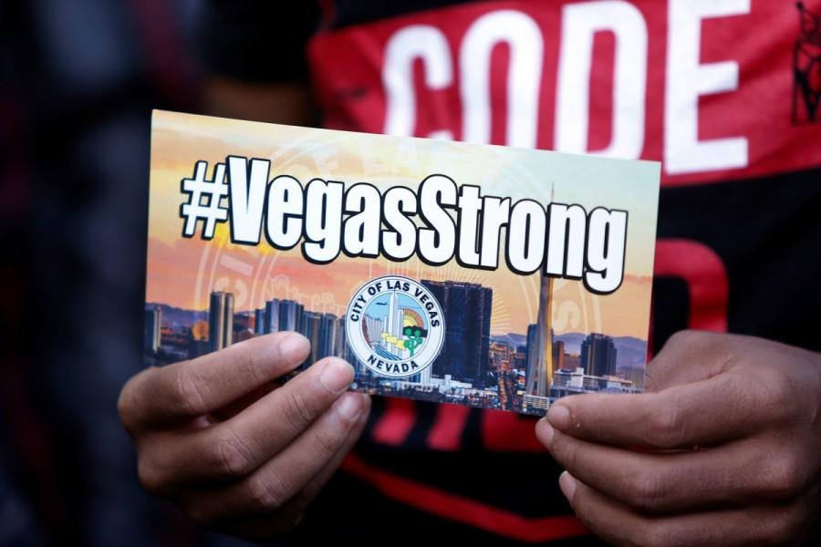 A man holds a sign with a VegasStrong hashtag during a prayer vigil in front of Las Vegas City Hall. Las Vegas,Mourning for Las Vegas,Las Vegas victims,Las Vegas shooting victims