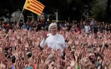 People raise their hands during a protest the day after the banned independence referendum in Barcelona.