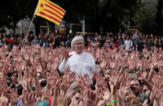 People raise their hands during a protest the day after the banned independence referendum in Barcelona.