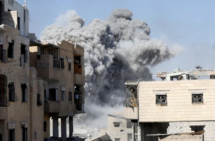 Smoke rises at the positions of the Islamic State militants after an air strike by the coalition forces near the stadium in Raqqa, Syria. Battle for Islamic State,Islamic State,U.S.-backed Syrian Democratic Forces,Syrian Democratic Forces