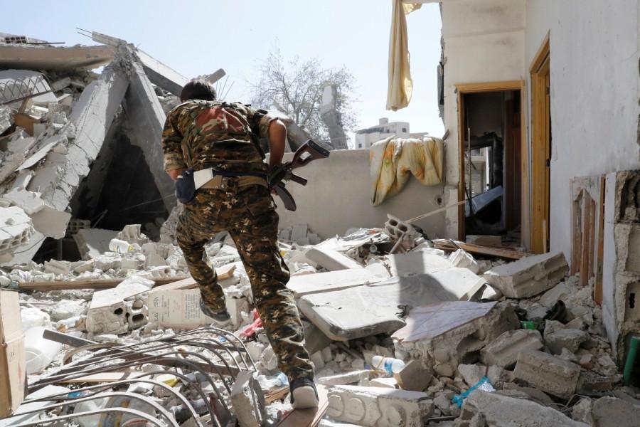 A member of Syrian Democratic Forces runs for cover to avoid sniper fire from Islamic State militants near the stadium in Raqqa. Battle for Islamic State,Islamic State,U.S.-backed Syrian Democratic Forces,Syrian Democratic Forces