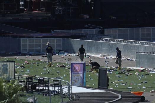 An FBI Evidence Response Team investigates the scene in front of the stage area.