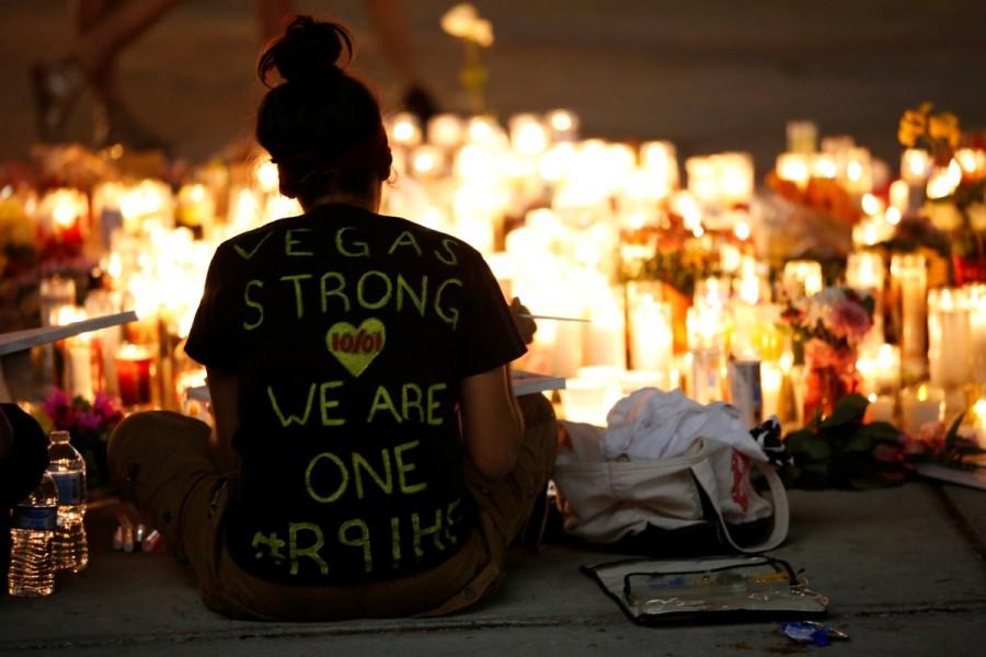 A woman makes a sign at a vigil on the Las Vegas strip. Las Vegas shooting aftermath,Las Vegas aftermath,Las Vegas shooting,Las Vegas,Aftermath in Las Vegas,Las Vegas in Aftermath