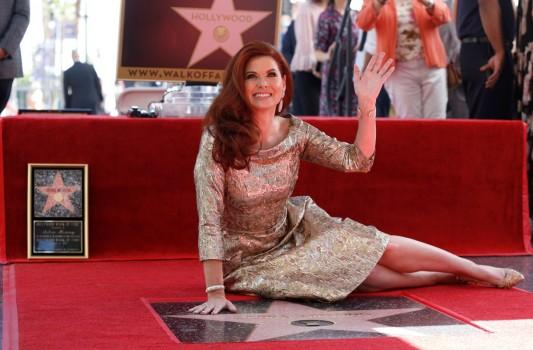 Actor Debra Messing poses on her star after it was unveiled on the Hollywood Walk of Fame in Los Angeles.