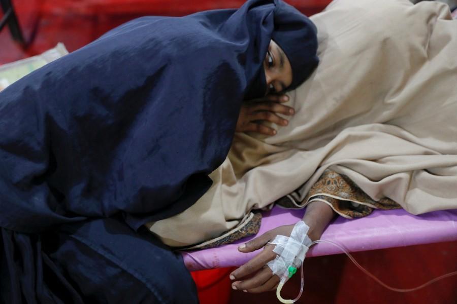 A woman comforts her husband suffering from severe diarrhoea at a dysentery clinic run by Medical Teams International in Kutupalong camp near Cox's Bazar, Bangladesh October 6, 2017. Rohingya refugee camps,Rohingya camps,refugee camps,Bangladesh