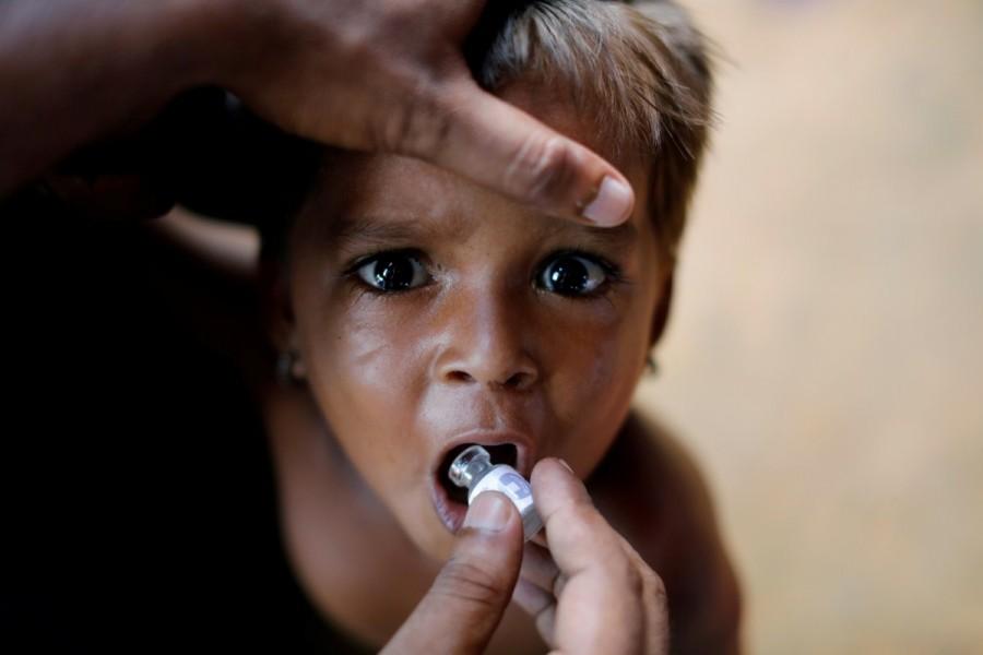 A Rohingya refugee child gets an oral cholera vaccine, distributed by the World Health Organisation (WHO) with the help of volunteers and local NGOs, in a refugee camp near Cox's Bazar, October 11, 2017. The WHO began distributing 900,000 doses of cholera vaccine on Tuesday in Bangladesh’s camps for Rohingya refugees fleeing from Myanmar, as authorities rush to prevent a major outbreak of the deadly disease. Rohingya refugee camps,Rohingya camps,refugee camps,Bangladesh