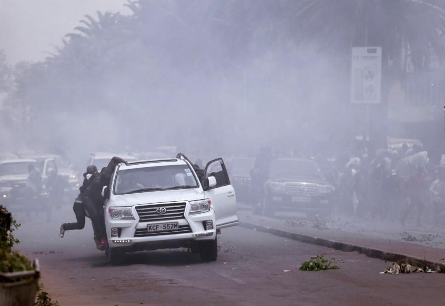 Opposition politicians of the National Super Alliance (NASA) coalition, evacuate after policemen fired tear gas to disperse them during a protest along a street in Nairobi. Kenya,Kenya election,kenya election 2017,Kenya election canceled,Police clash